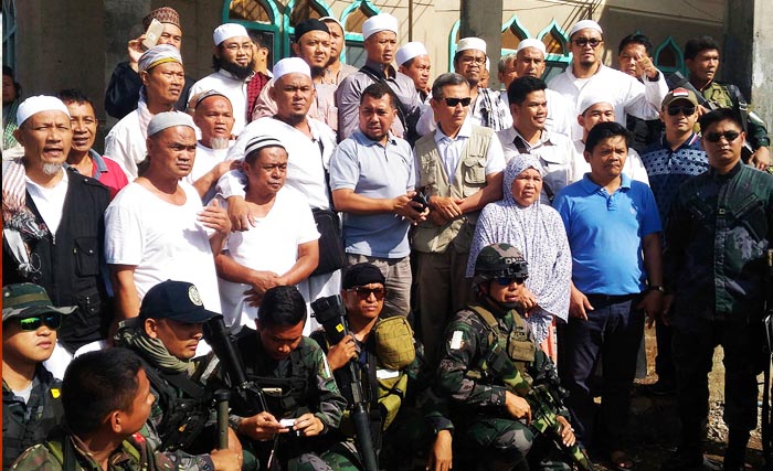 Sejumlah Warga Negara Indonesia (WNI) yang tergabung dalam jamaah tablig berfoto bersama dengan tim KBRI dan Angkatan Bersenjata Filipina sebelum dievakuasi dari Marawi City, Provinsi Lanao del Sur di Pulau Mindanao, Filipina, Kamis (1/6). Tim KBRI di Manilla dan Davao City dengan bantuan otoritas keamanan Filipina mengevakuasi 10 orang WNI dari Masjid Inu Daran di Marawi City dan enam orang WNI dari Masjid Al Kuwait di kota Sultan Naga Dimaporo ke Davao City untuk selanjutnya diterbangkan ke Indonesia terkait terjadinya konflik bersenjata antara pemerintah Filipina dengan kelompok militan Maute yang berafiliasi dengan ISIS di Marawi City.  (foto: adi guno/antara)