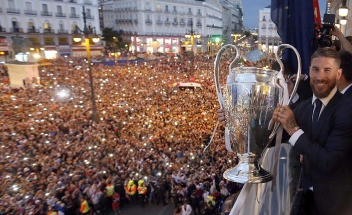 Kapten Real Madrid Sergio Ramos memegang trofi Liga  Champions  di depan ribuan penggemar Real Madrid, di balkon Kantor Otoritas  Kota Madrid, hari Minggu (4/6) malam waktu setempat. (foto: EPA)