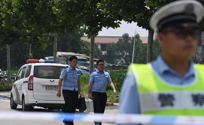 Polisi membawa perlengkapan di luar sebuah TK tempat ledakan menewaskan delapan orang dan melukai puluhan lainnya sehari sebelumnya, di Fengxian, di provinsi Jiangsu, 16 Juni 2017. Polisi Tiongkok mengatakan ledakan tersebut disebabkan oleh bom rakitan dan pengebomnya tewas di tempat. (foto:  greg baker/afp) 