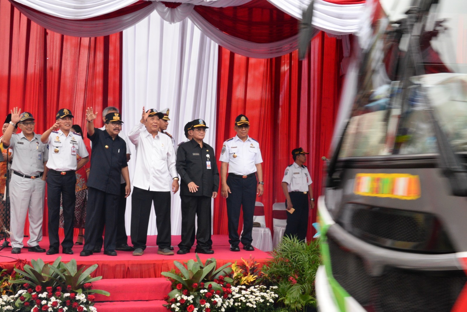 Pakde Karwo melambaikan tangan kepada para pemudik yang di berangkatkan secara langsung bertempat di depan Kantor Dishub LLAJ Pemprov Jatim Jl A Yani Surabaya, Kamis (22/6). (foto: Istimewa)