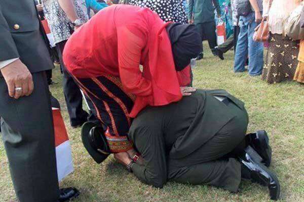 Seorang lulusan Akademi Angkatan Laut melakukan sungkem kaki pada ibunya, usai diwisuda. (foto: istimewa)