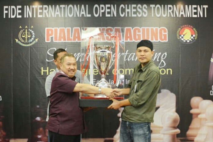 Kajati Jatim Maruli Hutagalung menyerahkan Piala Jaksa Agung kepada juara Kejuaraan Fide Internasional Open Chess Tournament , Hamdani Rudin di Aula Kejati Jatim. Foto:ngopibareng.id/tom 