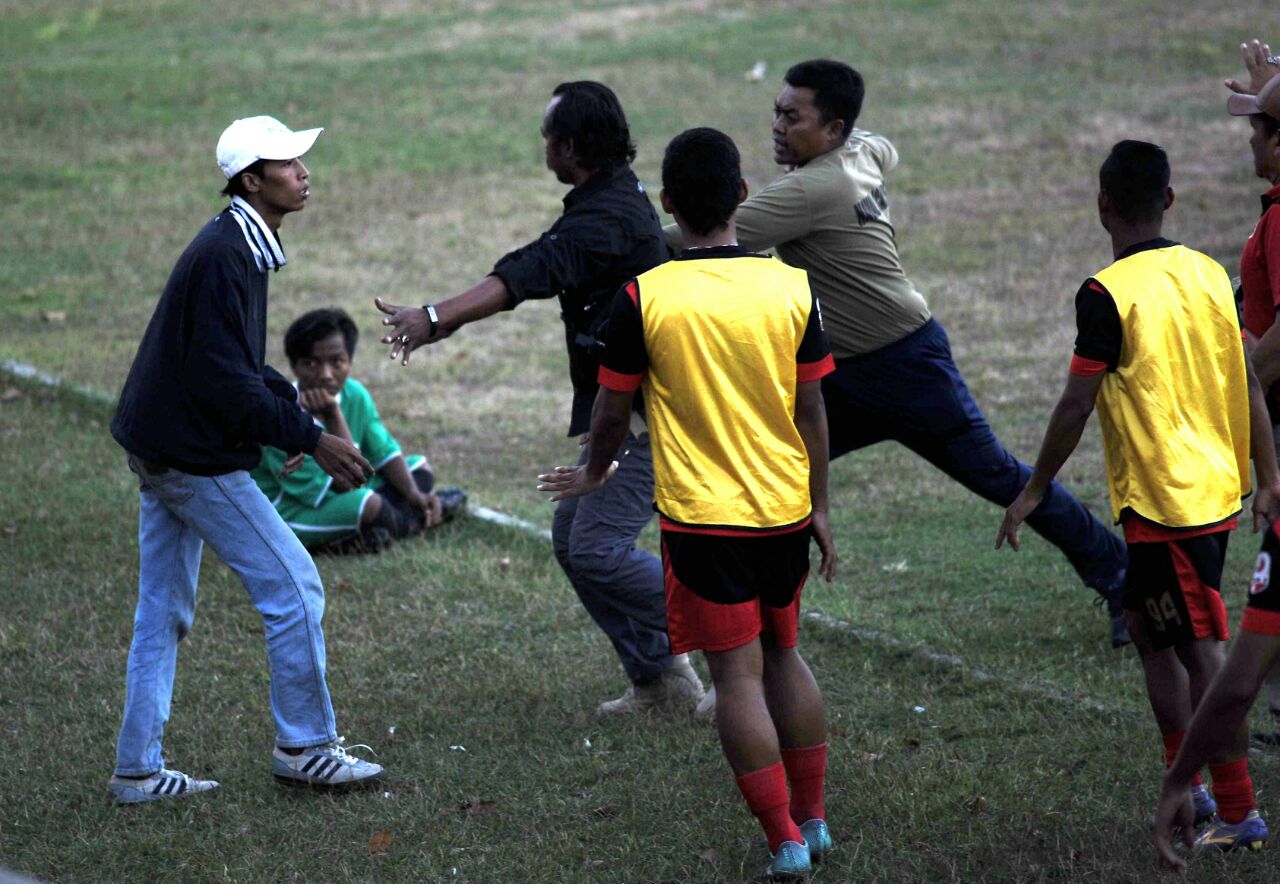 Petugas menghalau seorang suporter yang ikut terlibat  dalam aksi kericuhan di menit 84. foto:ngopibareng.id/tomi 