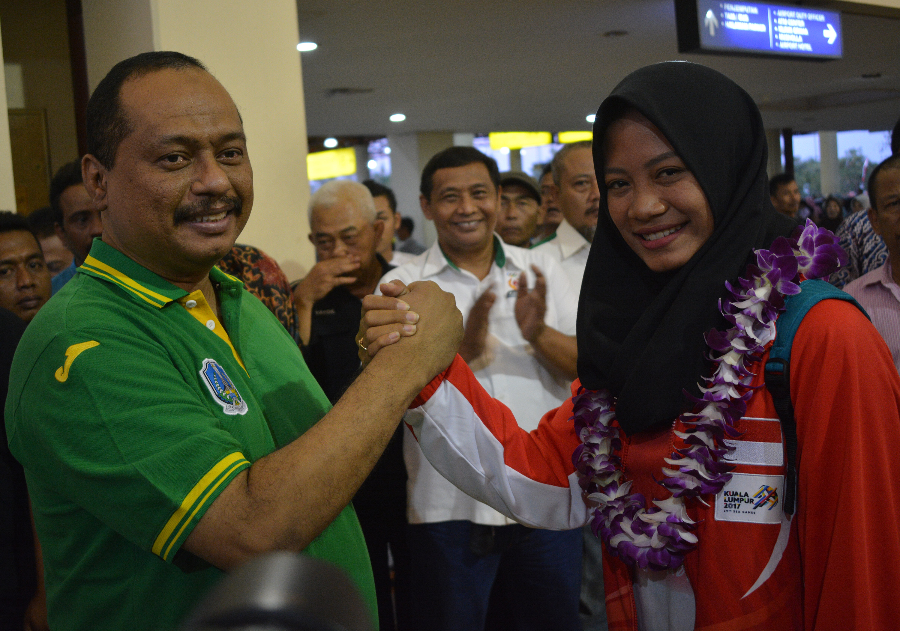 Ketua Harian KONI Jatim, M. Nabil (kiri) saat menyambut kedatangan atlet panahan yang meraih dua emas dan satu perak, Diananda Choirunisa (kanan), di Bandara Internasional Juanda, Surabaya, Jumat (25/8). (foto: hrs/ngopibareng.id)