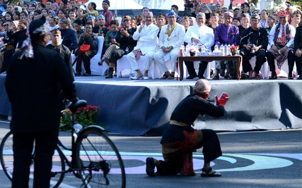 Presiden Joko Widodo mengenakan beskap ungu dan iket kepala Makuta Sinatria serta kudjang naga salapan lobang menyaksikan  Karnaval Kemerdekaan Pesona Parahyangan Tahun 2017 dari podium yang telah disediakan di Taman Vanda Bandung, Sabtu, (26/8/2017). (Foto: Biro Pers/Setpres)