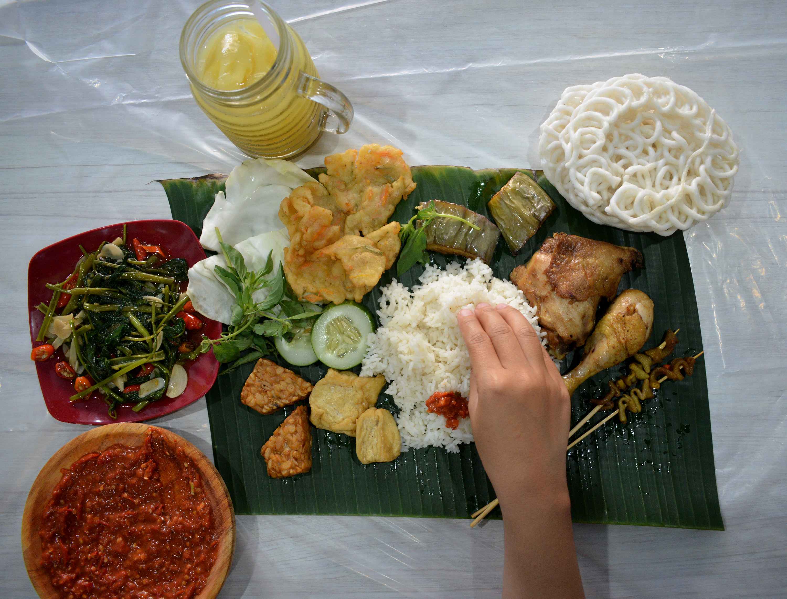 Menu yang di Segobancakan.sub, dengan beralasan daun dan ala makan di syukuran. (foto: hrs/ngopibareng.id)