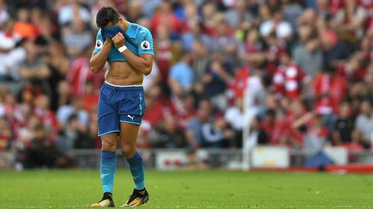 Striker Arsenal Alexis Sanchez menutup muka usai timnya diberondong empat gol tanpa balas oleh Liverpoll, tadi malam.  