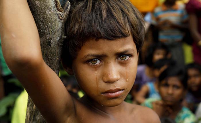 Gadis cilik Rohingnya berdiri di depan pengungsi yang baru tiba di Bangladesh dari Myanmar di Ukhiya, Rabu (6/9) kemarin.  Lebih dari 125 ribu pengungsi membanjiri perbatasan Bangladesh, yang sebagian besar Rohingnya. (foto: km. asad/afp) 