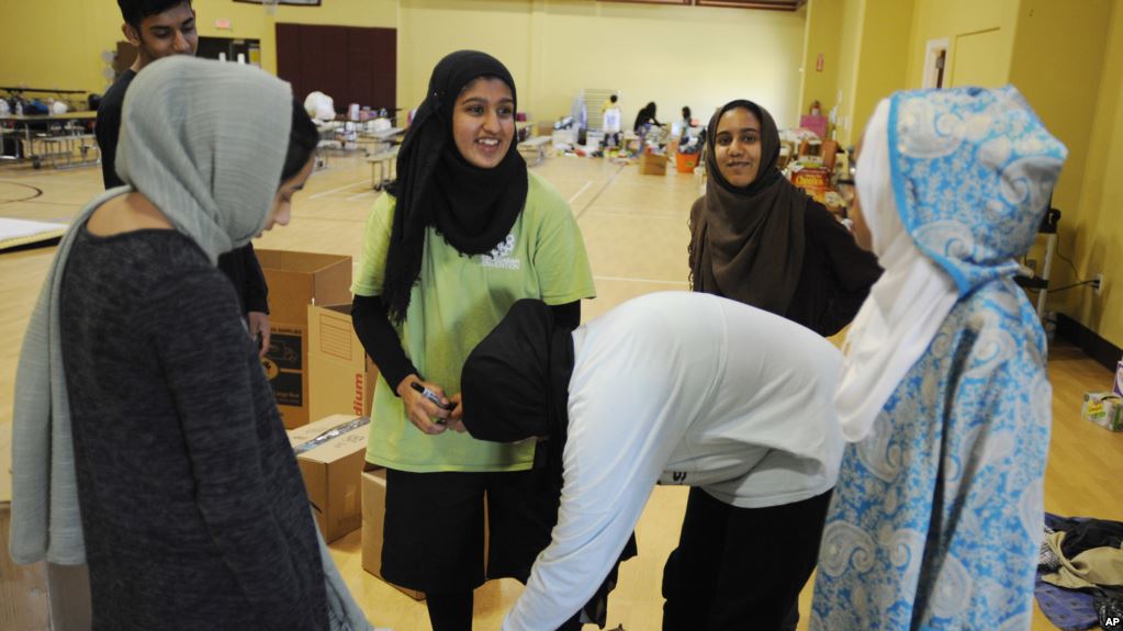 BANTUAN: Relawan Islamic Society of Greater Houston, AS, menyerahkan paket bantuan di sebuah masjid, sebagai tempat berteduh bagi para korban badai Harvey. (foto: VoA)