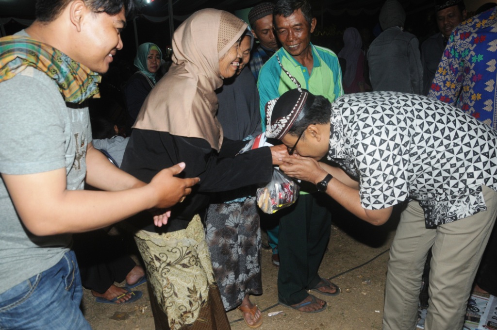 Gus Ipul mencium tangan seorang ibu sepuh saat menyaksikan nonton bareng Festival Wayang Kulit 2017 di Lapangan Desa Slorok Kecamatan Kromengan Kabupaten Malang, Rabu, 13 September 2017. (Foto: ngopibareng.id)