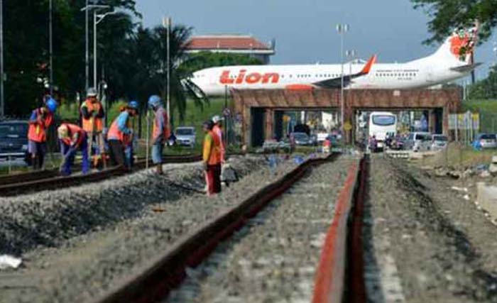 Para pekerja sedang menyelesaikan pemasangan rel untuk kereta api jalur Jakarta - Bandara Soeta. (foto: kabarpenumpang.com)
