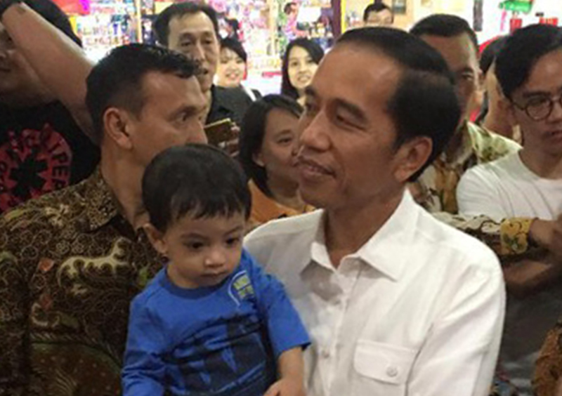 Presiden Jokowi saat menggendong cucunya usai tiba di Solo. (foto: detik)