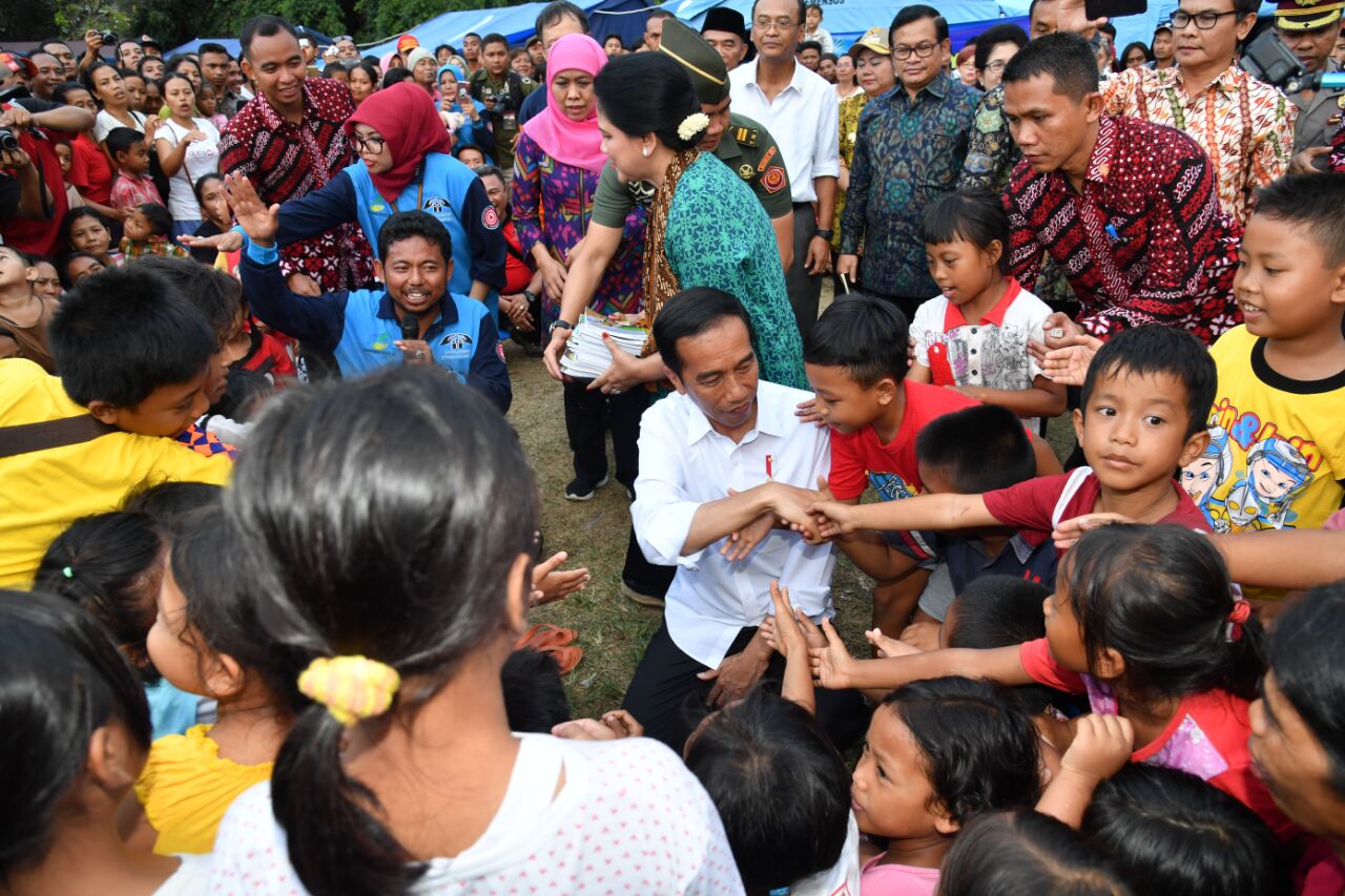 Presiden Joko Widodo dan Ibu Negara Iriana Joko Widodo menyerahkan langsung bantuan kepada warga yang mengungsi di Posko Tanggap Darurat Erupsi Gunung Agung di Kabupaten Karangasem, Provinsi Bali, Selasa 26 September 2017. (Foto: Biro Pers/Setpres) 