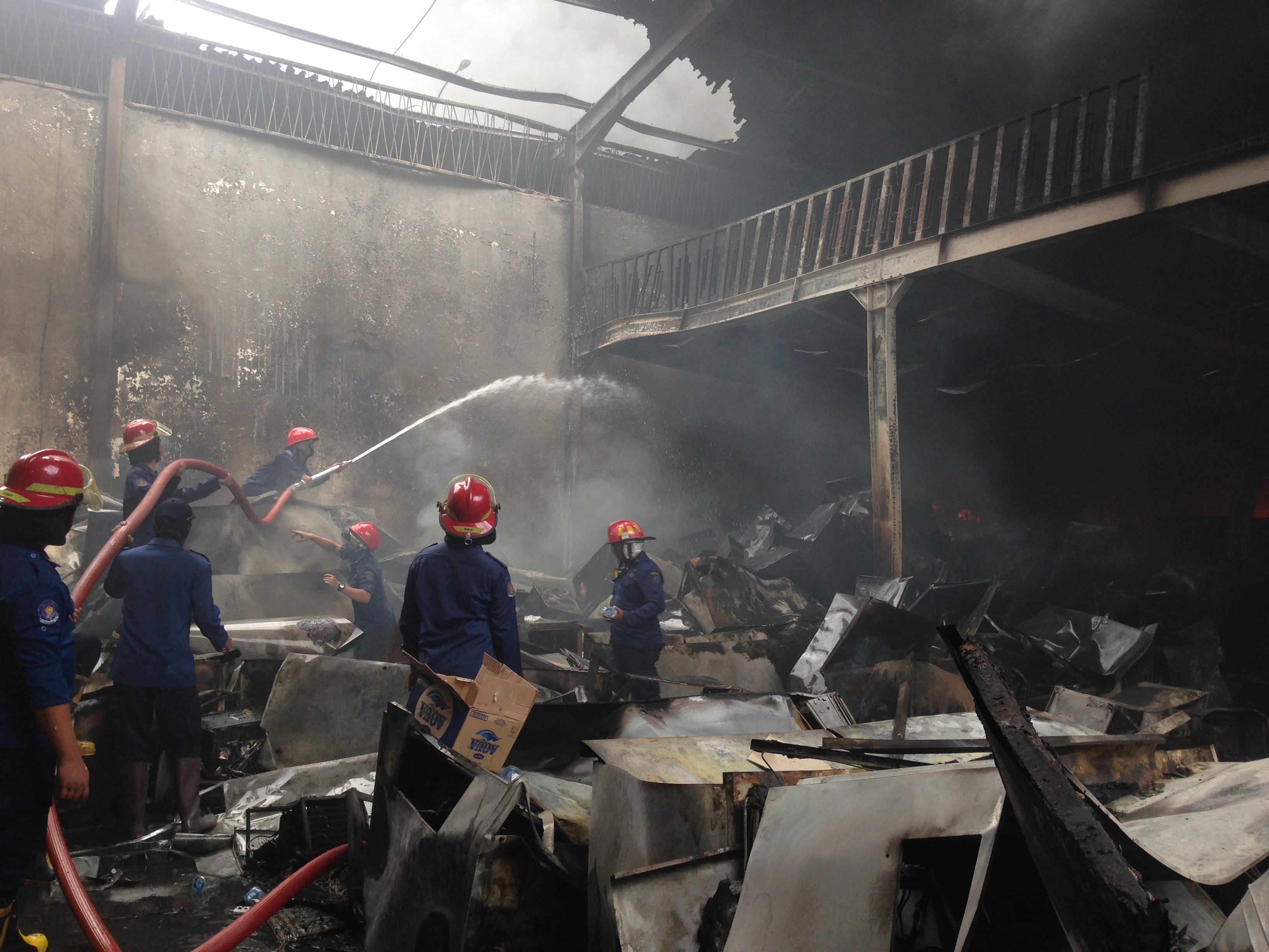 Petugas tengah memadamkan api di dalam gusang PT. Getra, Rabu, 27 September 2017. (Foto: frd/ngopibareng.id)