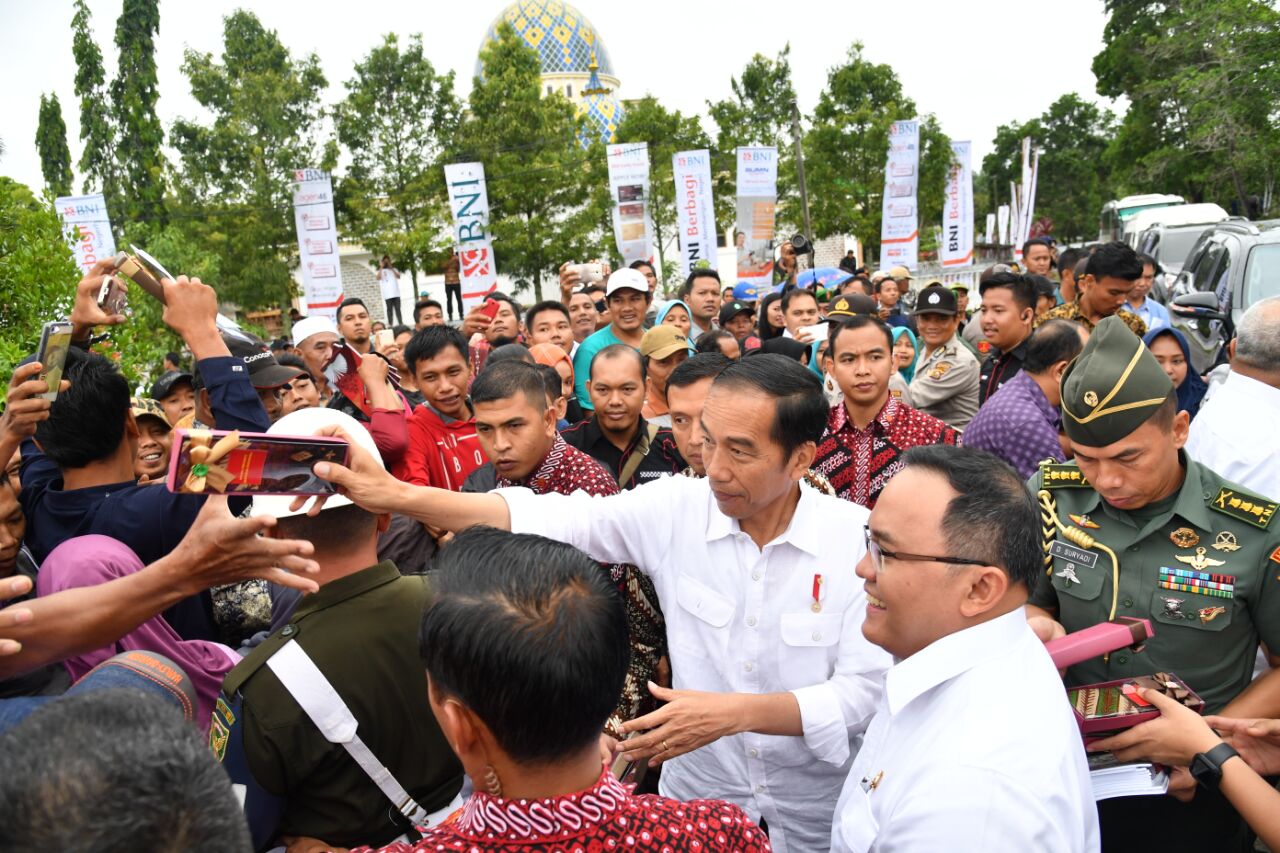 Presiden Joko Widodo menyapa masyarakat saat menghadiri acara Penanaman Perdana Program Peremajaan Kebun Kelapa Sawit dan Penyerahan Sertifikat Tanah untuk Rakyat di Kabupaten Musi Banyuasin, Jumat 13 Oktober 2017. (Foto Biro Pers/Setpres) 