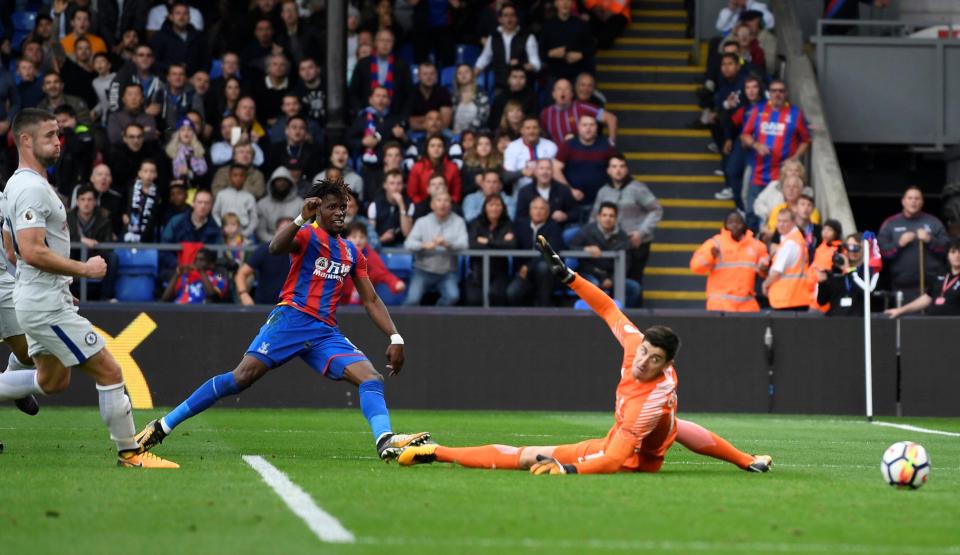 Kiper Chelsea Courtois tak bisa membendung tendangan striker Crystal Palace, Zaha. 