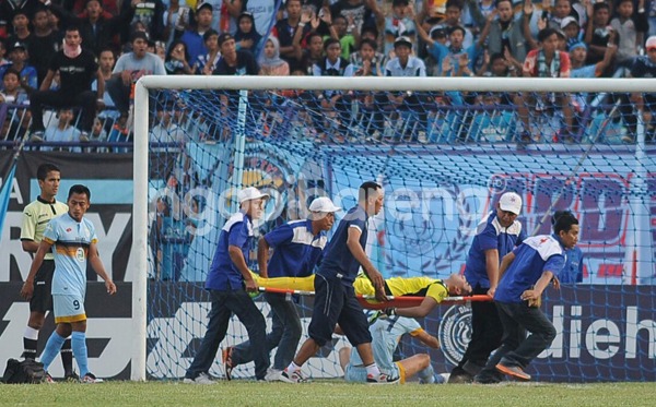 Kiper Persela Choirul Huda saat ditandu keluar lapangan dengan kondisi tak sadarkan diri. foto:ngopibareng.id