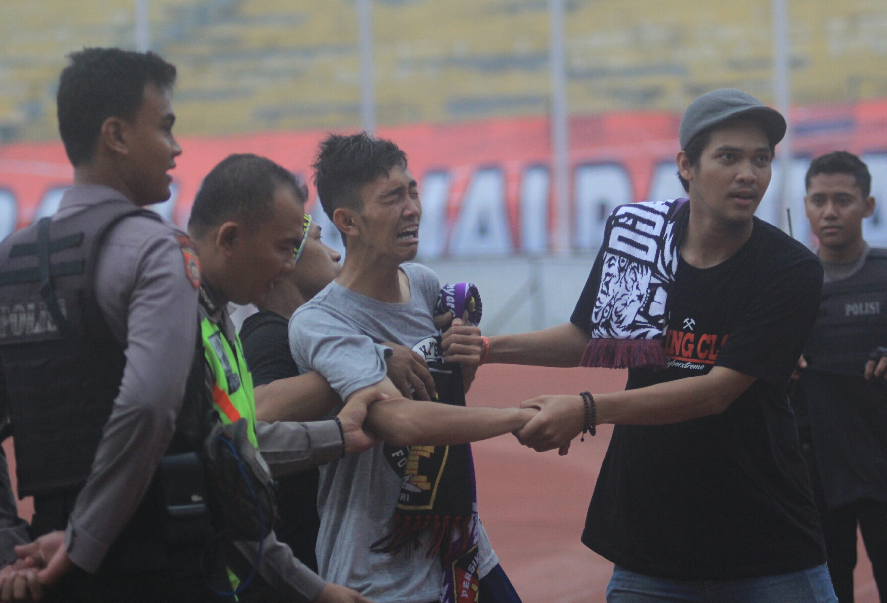 Salah satu Persik Mania menangis histeris sambil mencoba masuk ke lapangan setelah Persik kalah dari PSIR 0-1 , petang tadi.foto:ngopibareng.id/tomy