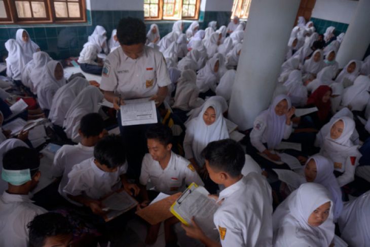 Siswa mengerjakan soal ujian akhir semester (UAS) mata pelajaran Matematika di kelas darurat Masjid Jami' Arjosari, di Pacitan, Jawa Timur, Selasa, 5 Desember 2017. Sebanyak 760 siswa SMPN Arjosari mengikuti UAS di dua masjid desa karena sekolah mereka rusak diterjang banjir beberapa waktu lalu. (Foto: Antara)