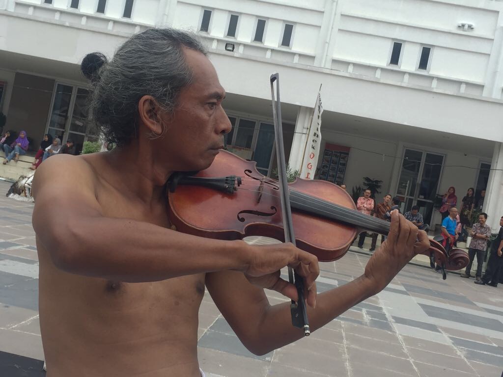 Performance art dari seorang musisi yang memainkan biola, di lapangan tengah, Balai Pemuda, Jumat, 22 Desember 2017. (Foto: farid/ngopibareng.id)