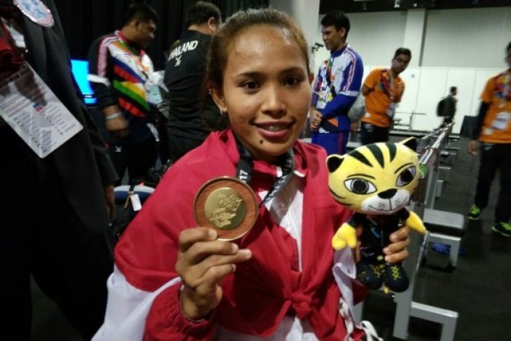 Atlet angkat berat difabel Indonesia, Ni Nengah Widiasih, berpose dengan medali emas ASEAN Para Games 2017 yang diraihnya lewat kelas -45 kilogram putri di Kuala Lumpur, Malaysia. Widiasih ingin mengulang sukses serupa di Asian Para Games 2018, (Foto: ANTARA)