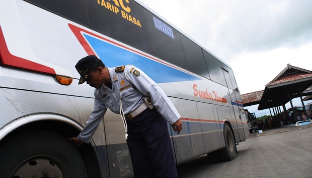 Petugas Dinas Perhubungan sedang memeriksa ban depan sebuah bus. (Foto: Dokumentasi)