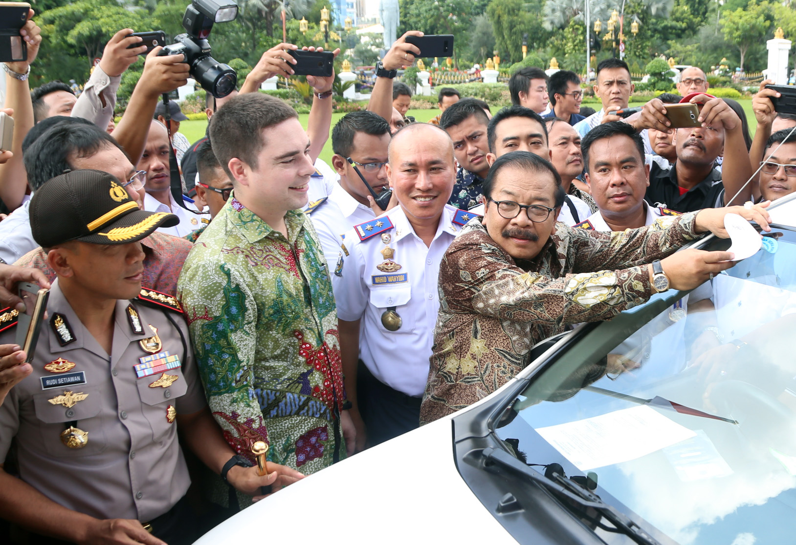 Gubernur Soekarwo ketika menempelkan stiker izin resmi angkutan online di Grahadi, Kamis (4/1). (Foto : Humas Jatim)