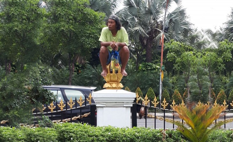 Orang itu mulanya duduk-duduk diatas pagar Grahadi, sembari membawa dua botol molotov. Sabtu, 6 Januari 2018. (foto: istimewa/rahmat)