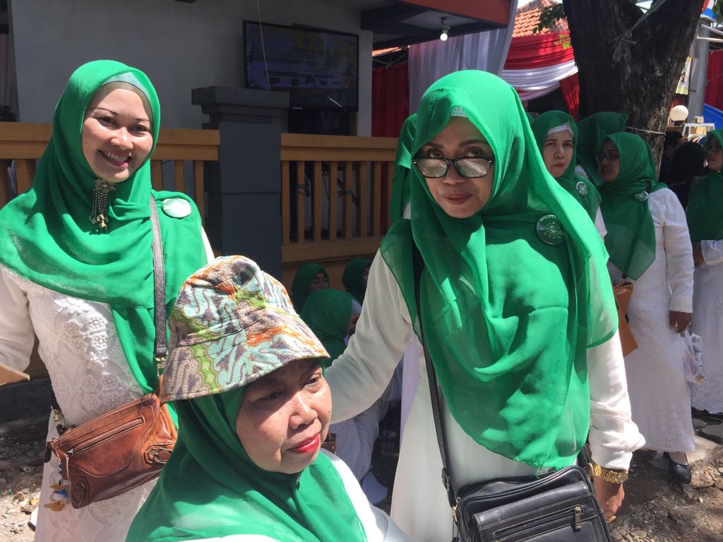 Sejak pagi, sejumlah 25 orang Ibu-ibu bergerombol di depan kantor Komisi Pemilihan Umum (KPU) Jatim, di bilangan Tenggilis Surabaya. Mereka berseragam putih, berjilbab berwarna hijau, dan terselip pin berlogo Muslimat Surabaya. (Foto: farid/ngopibareng.id)