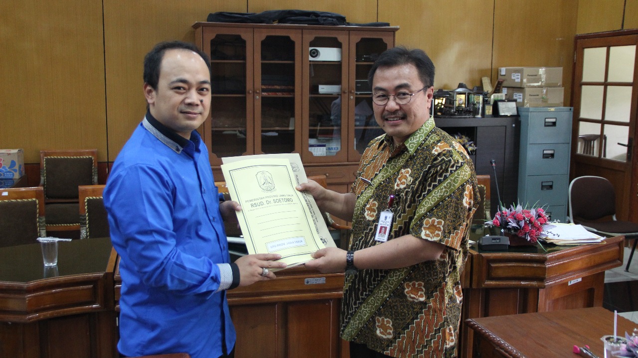 Ketua Tim Pemeriksaan Kesehatan Bacalon Gubernur dan Wakil Gubernur Jatim, dr. Joni Wahyuhadi, menyerahkan berkas hasil tes pemeriksaan kesehatan, kepada Divisi Teknis KPU Jatim, Muhammad Arbayanto, Selasa 16 Januari 2018. (Foto: Ist)