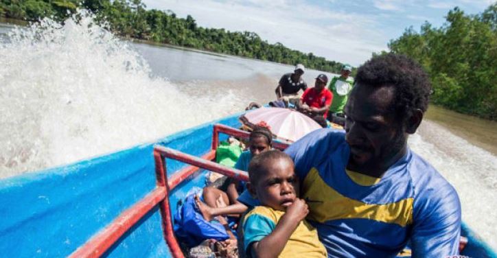 Warga menggendong anaknya di perahu. (Foto: Antara)