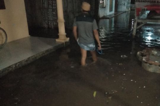 Seorang warga Situbondo berjalan di depan rumah akibat banjir Rob. (Foto : antara)