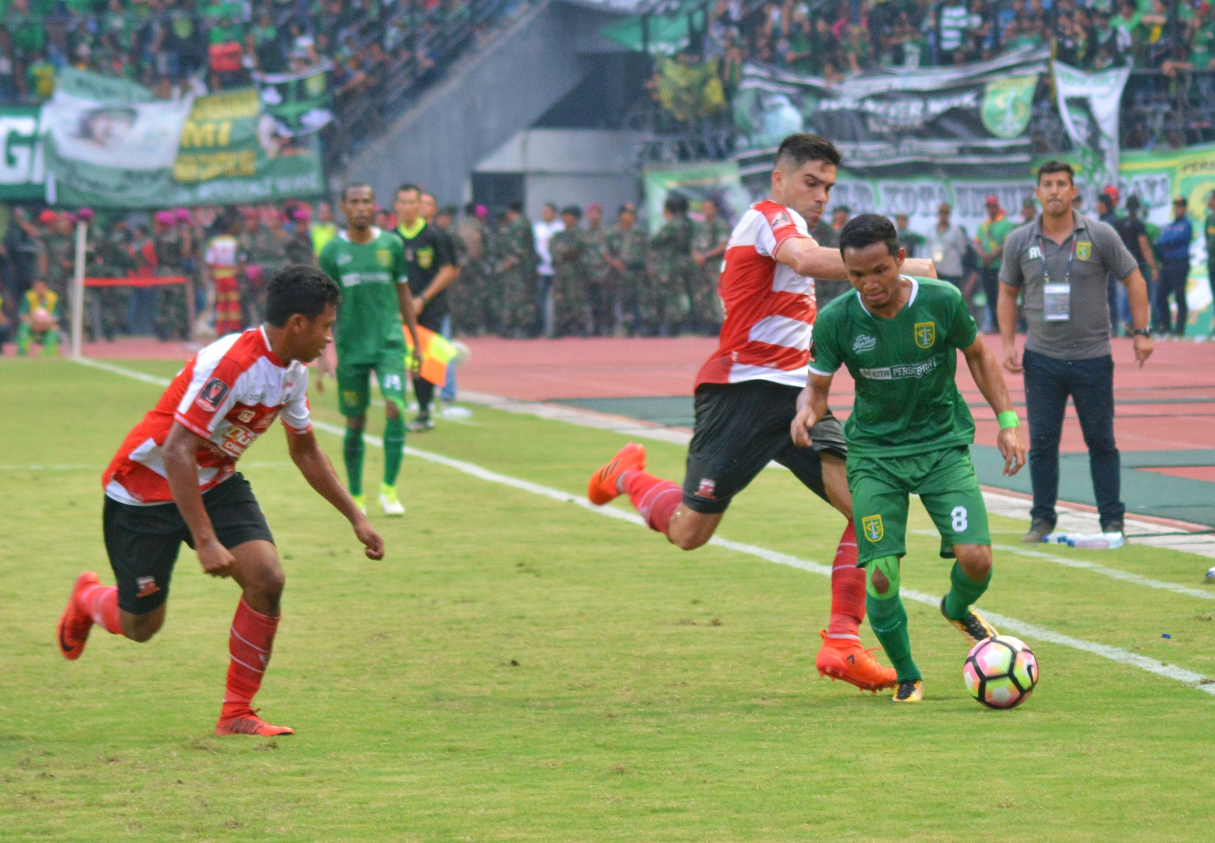 Pemain Persebaya Oktavianus Fernando saat melewati kedua pemain Madura United, dalam pertandingan yang dimenangkan oleh Bajol Ijo, pada Minggu 28 Januari 2018. (foto: hrs/ngopibareng)