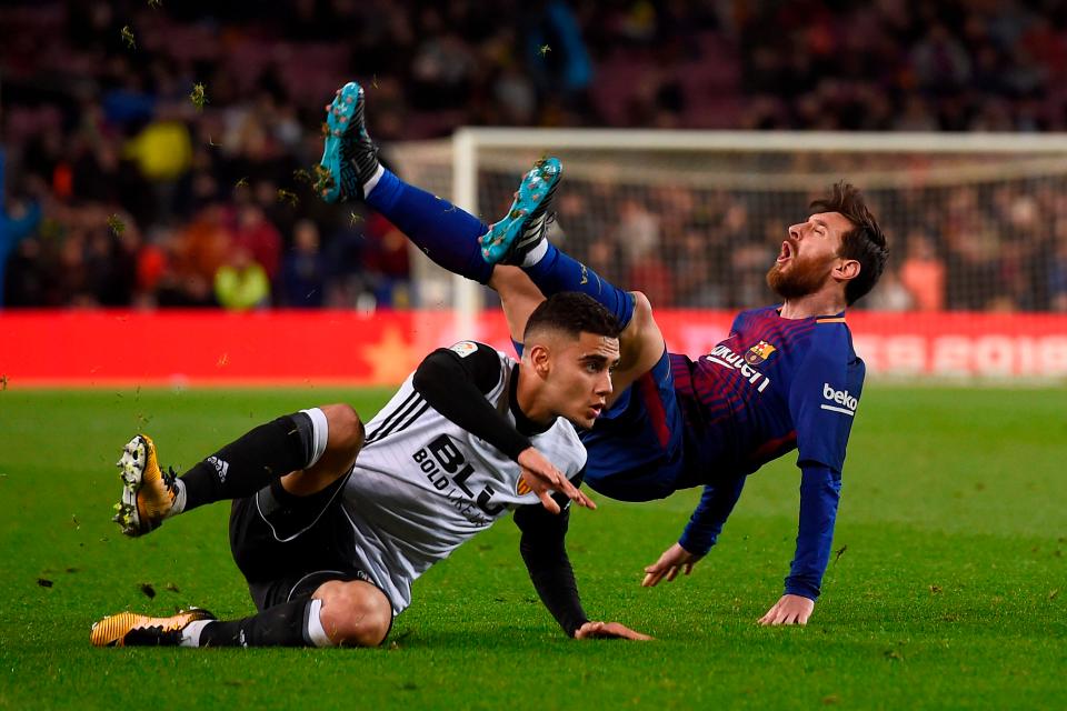 Lionel Messi mendapatkan tackling keras dari pemain Valencia dalam laga semifinal pertama Copa del Rey, dini hari tadi; foto:afp