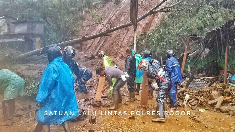 Satuan Lalu-lintas Polres Bogor saat membersihkan jalan yang tertimbun longsor di Riung Gunung, Kecamatan Cisarua, Kabupaten Bogor. (Foto: Detik)