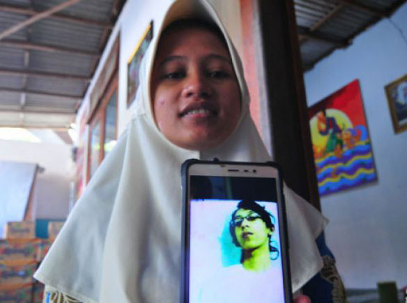 Sianit Sinta menujukkan foto mendiang suaminya Ahmad Budi Cahyanto guru SMAN 1 Torjun yang tewas dipukul siswanya sendiri, di Desa Tanggumung, Sampang, Jawa Timur, Sabtu 3 Februari 2018. Ahmad Budi Cahyanto tewas dipukul siswanya sendiri MH saat pelajaran berlangsung, Jumat, 1 Februari 2018. (Foto: Antara)