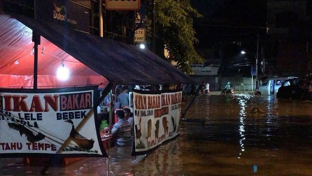 Warung pecel lele yang tetap buka meski banjir melanda.