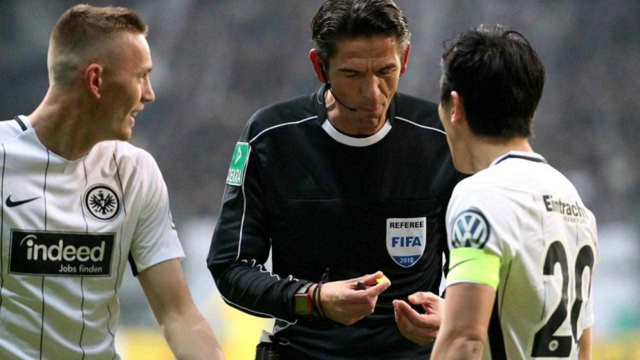 Wasit Deniz Aytekin menjadi sorotan setelah aksinya memakan permen yang dilempar penonton di Liga Jerman. foto:afp