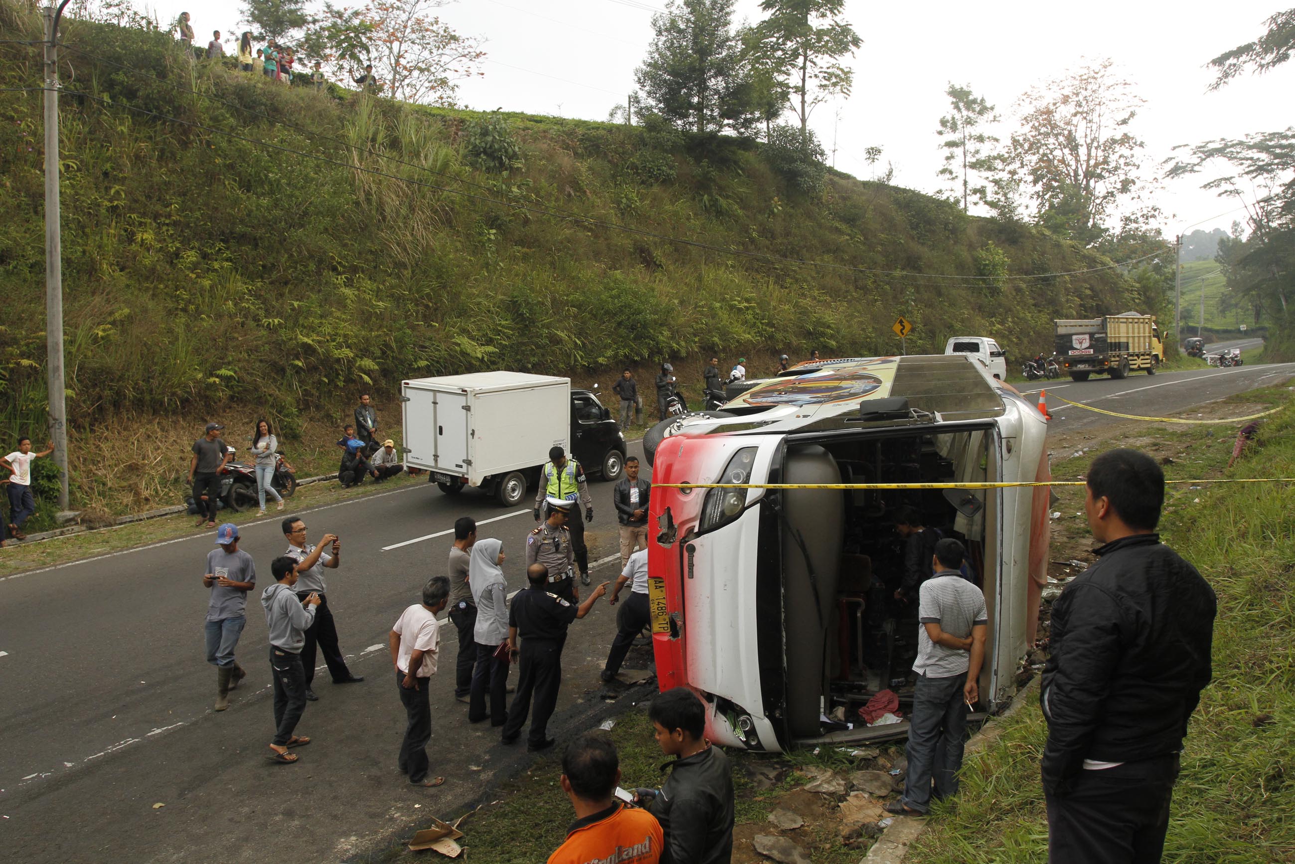 Bus pariwisata merek Mercedez Benz milik Dian Mitra asal Magelang terguling setelah menabrak dinding perkebunan teh di Tanjakan Emen, Kabupaten Subang, Jawa Barat, Senin (1/10). Kecelakaan ini mengakibatkan tiga wisatawan asal Tiongkok dan seorang pemandu wisata dari Indonesia meninggal dunia dan belasan wisawatan asal Taiwan mengalami luka-luka. (Foto: Suara Pembaruan/Adi Marsiela)