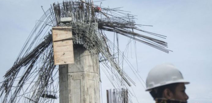 Pekerja beraktivitas di dekat tiang pancang yang roboh pada proyek kontruksi pembangunan tol Bekasi-Cawang-Kampung Melayu (Becakayu) di Jalan D I Panjaitan, Jakarta, Selasa 20 Februari 2018. Tiang pancang pada proyek kontruksi pembangunan tol Bekasi-Cawang-Kampung Melayu (Becakayu) yang roboh pada Selasa, 20 Februari 2018 sekitar pukul 03.00 WIB itu menyebabkan tujuh pekerja dari proyek tersebut terluka. (Foto: Antara)