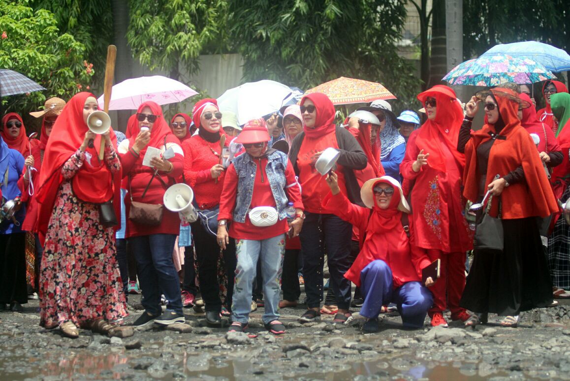 Ratusan ibu-ibu tampak memukul berbagai alat dapur di sepanjang Jalan Delta Sari, Sidoarjo, Jumat 23 Februari 2018. (foto: tom/ngopibareng)