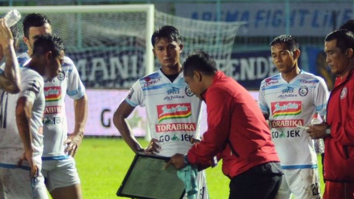 Pemain Arema mendengarkan instruksi pelatih Joko Susilo. foto:ist  