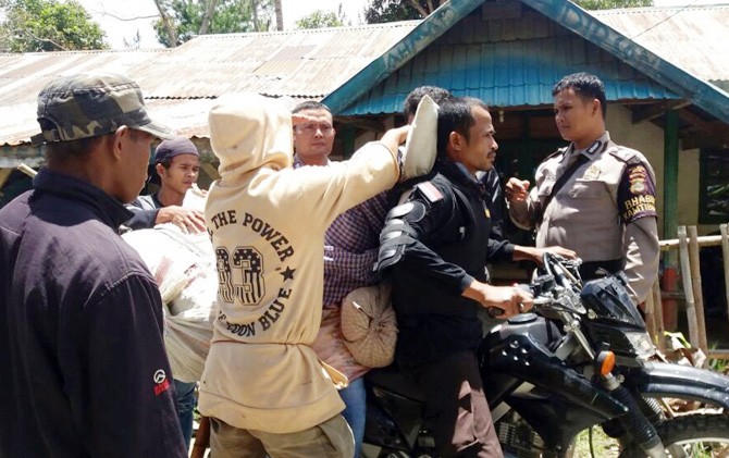 Bhabinkatibmas Polres Sigi, Bripka Rizal saat membonceng jenazah warga Desa Wawujai, Kecamatan Marawola Barat, Kabupaten Sigi (Foto: DOK. POLRES SIGI)