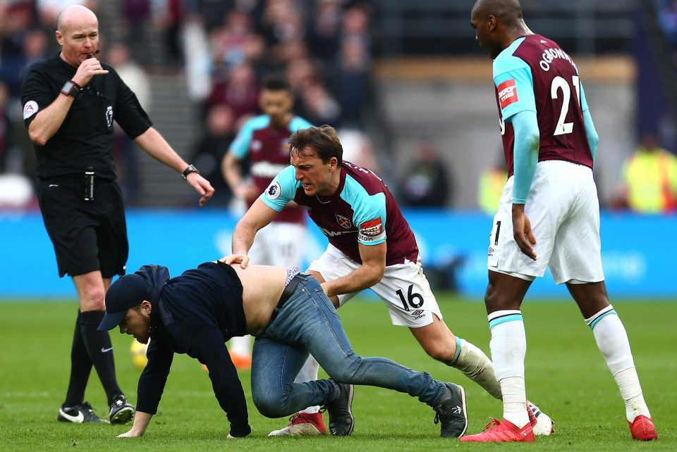 Pemain West Hams pontang-panting mengehentikan suporter yang menganggu jalannnya pertandingan.  foto:afp