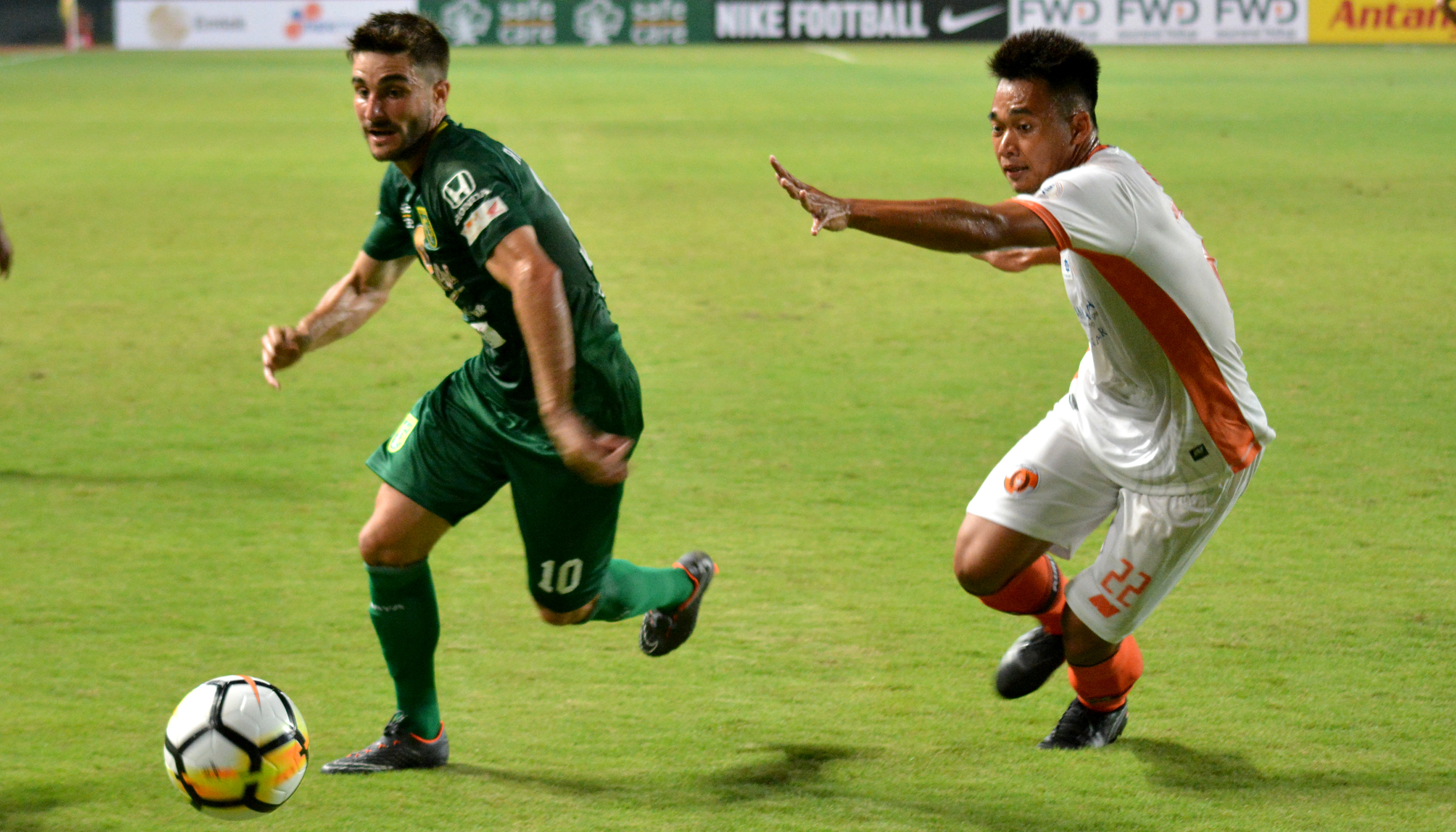 pemain Persebaya, Robertino Pugliara (kiri) saat berduel dengan Pemain Perseru Serui Indra Permana dalam pertandingan perdana Liga 1, pada Minggu 25 Maret 2018. (foto: hrs/ngopibareng)