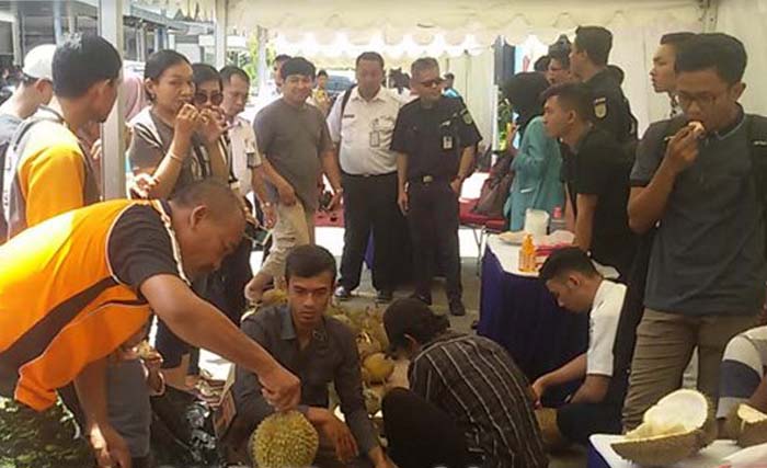 Penumpang kereta api menikmati durian gratis di stasiun Madiun, Jumat 30 Maret 2018. (foto: dok. surya)