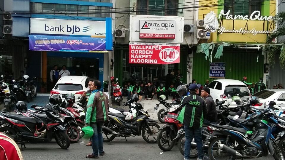 Para pengemudi ojek online masih menunggu perundingan perwakilannya dengan manajemen Grab dan Goj-jek, di Kantor Grab di Ruko Klampis, Jalan Klampis Jaya, Surabaya, Senin 2 April 2018. (Foto: frd/ngopibareng.id)