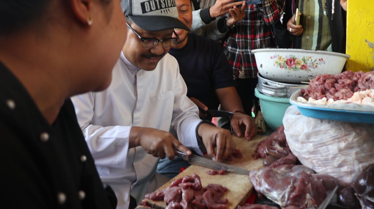 Gus Ipul berbincang ringan dengan penjual sate dan mencoba memotong daging bahan sate. (Foto: Istimewa)