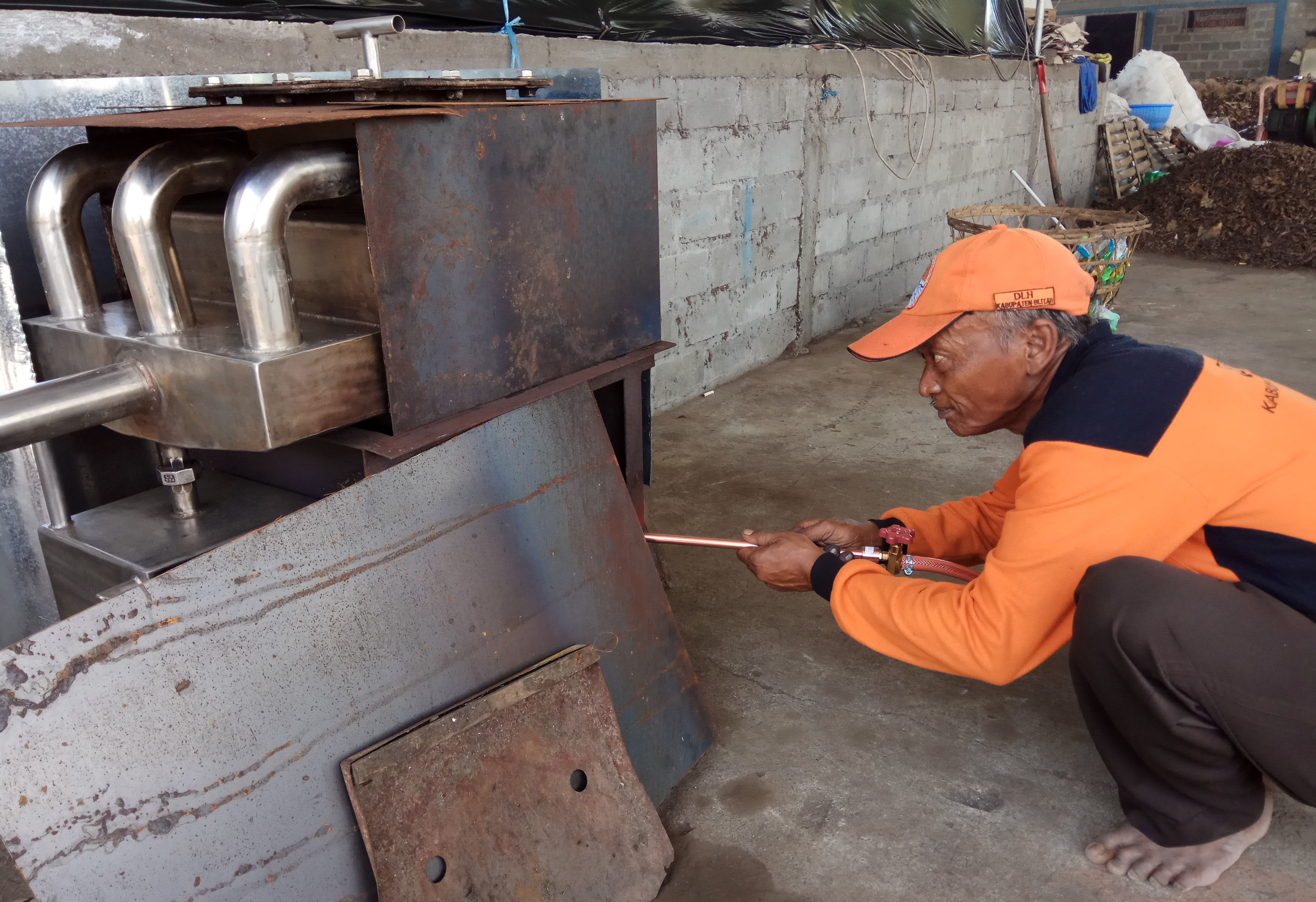 Muryani mengecek nyala api pada destilator sampah plastik ciptaannya. (Foto; Istimewa)