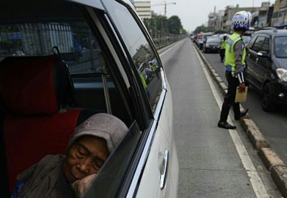 Seorang ibu tertidur dalam kendaraan yang ditilang polisi saat Operasi Zebra Jaya 2014 di kawasan Terminal Senen, Jakarta Pusat, Rabu 26 November 2014. Operasi Zebra itu tersebut didukung 2.800 personel Kepolisian Daerah Metro Jaya dan berlangsung 26 November sampai 9 Desember 2014 untuk menekan jumlah pelanggaran lalu lintas. (Foto: Antara)